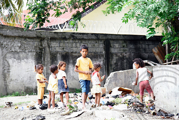 Poverty stricken children search through rubbish in Timor Leste