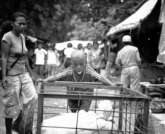 A young boy pushes a heavy cart at a market in Timor Leste